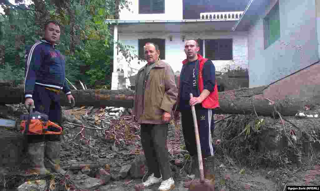 Residents work to clear fallen trees. 