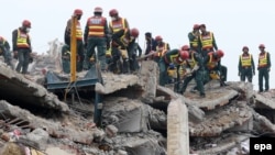 Pakistani army soldiers and rescue workers search for survivors amid rubble of a factory that collapsed in Lahore on November 5.