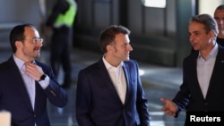 French President Emmanuel Macron (center), Cypriot President Nikos Christodoulides (left), and Greek Prime Minister Kyriakos Mitsotakis speak to each other at Paphos military airport on March 9.