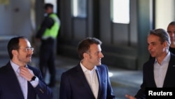 Președintele francez Emmanuel Macron (centru), președintele cipriot Nikos Christodoulides (stânga) și premierul grec Kyriakos Mitsotakis discută la aeroportul militar din Paphos, pe 9 martie.