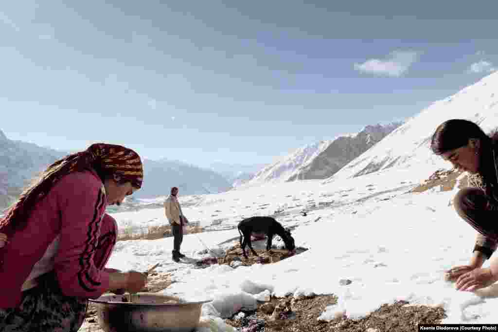 Young women wash the entrails of a slaughtered sheep in a river in the Pamir mountains.