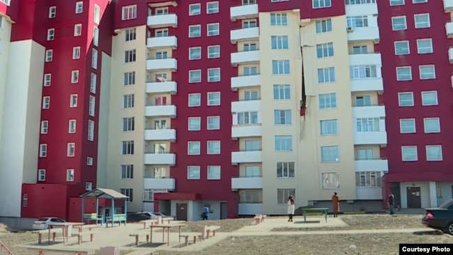 "Нұрлы жер" мемлекеттік бағдарламасы бойынша салынған көпқабатты тұрғын үйдің сыртқы қаптамасы жалбырап, түсіп жатыр. Өскемен, 2021 жылғы сәуір айында түсірілген.