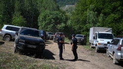 Policia e Kosovës qëndron pranë një vendi të dyshuar si varrezë masive, të zbuluar rishtazi në fshatin Kalludër, afër qytetit të Zubin Potokut, më 1 gusht 2026.