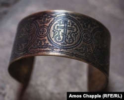 A bracelet featuring the Orthodox Christian cross, cut from a spent artillery shell