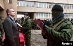 Serghei Aksionov ascultând depunerea jurământului de către un membru al "forțelor militare ale Crimeei".