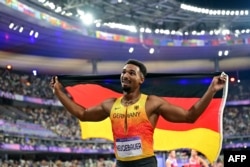 Лео Нойгебауер ликува с германския флаг след като е завършил втори в десетобоя на Олимпиадата в Париж, 3 август 2025 г.