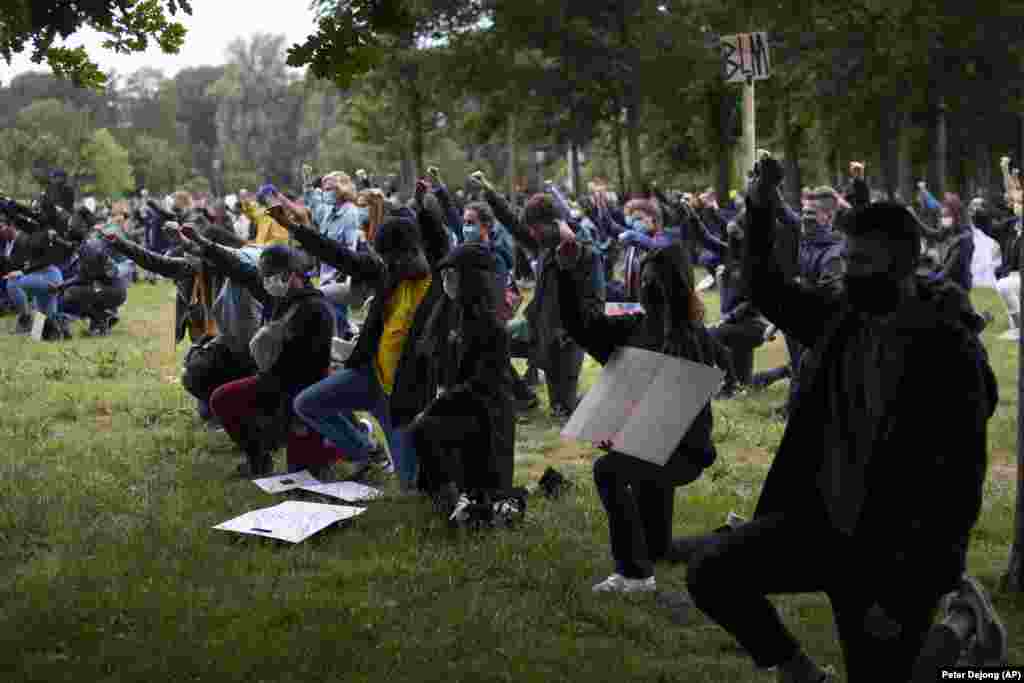 Люди стоять на коліні зі стиснутим кулаком, демонструючи підтримку рухові Black Lives Matter у парку в Амстердамі, названому на честь борця за права чорношкірих, південноафриканця Нельсона Мандели. У нідерландських містах пройшла серія протестів через смерть Джорджа Флойда у штаті Міннесота 25 травня 2020 року