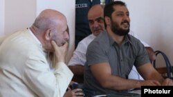 Armenia - Father Anton Totonjian (L) and Artur Vartanian (R) stand trial on coup charges in Yerevan, 28Jul2017.