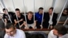 Ukrainian sailors sit inside the defendants' cage prior to a hearing at a court in Moscow on July 17.