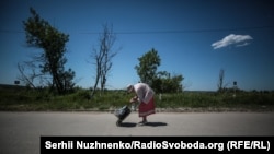 Женщина переходит с оккупированной территории на подконтрольную Украине. Станица Луганская, лето 2019 года 