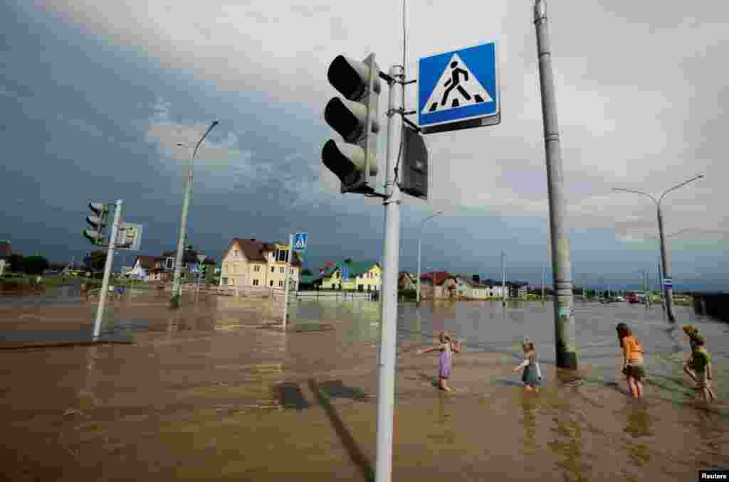 Children play on a flooded street after heavy rain in Minsk (Reuters/Vasily Fedosenko)