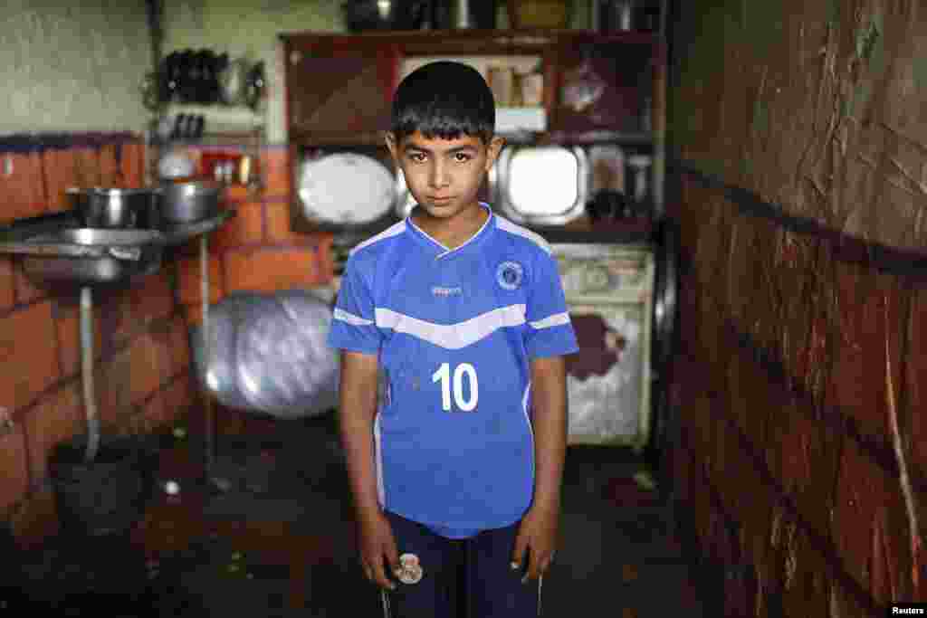 Hassoun Karroum Hirmiz, who is blind, poses for a picture inside his house in the Al-Fdhiliya district.