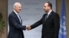 UN Special Envoy for Syria Staffan de Mistura (L) shakes hands with Syria's rebel delegation chief Nasr al-Hariri.
