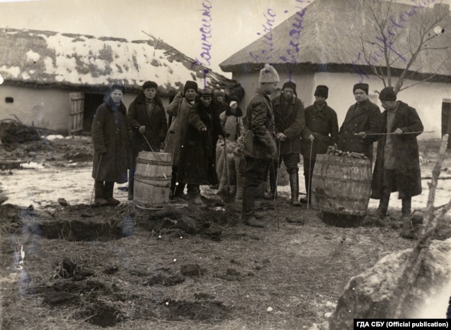 На фото одна із тисяч буксирних бригад, яка конфісковувала у селян продовольство. В їхніх руках металеві штики ‒ щупи. Ними радянські активісти шукали у землі заховане зерно, а насправді – всю знайдену їжу