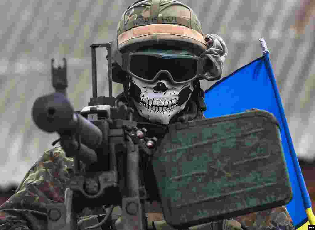 Maskirani ukrajinski vojnik nosi šljem na kojem piše &quot;Rat je pakao&quot; (War is Hell). Fotografija zabilježena u blizini grada Debaltseve. (epa/Konstantin Grishin) 