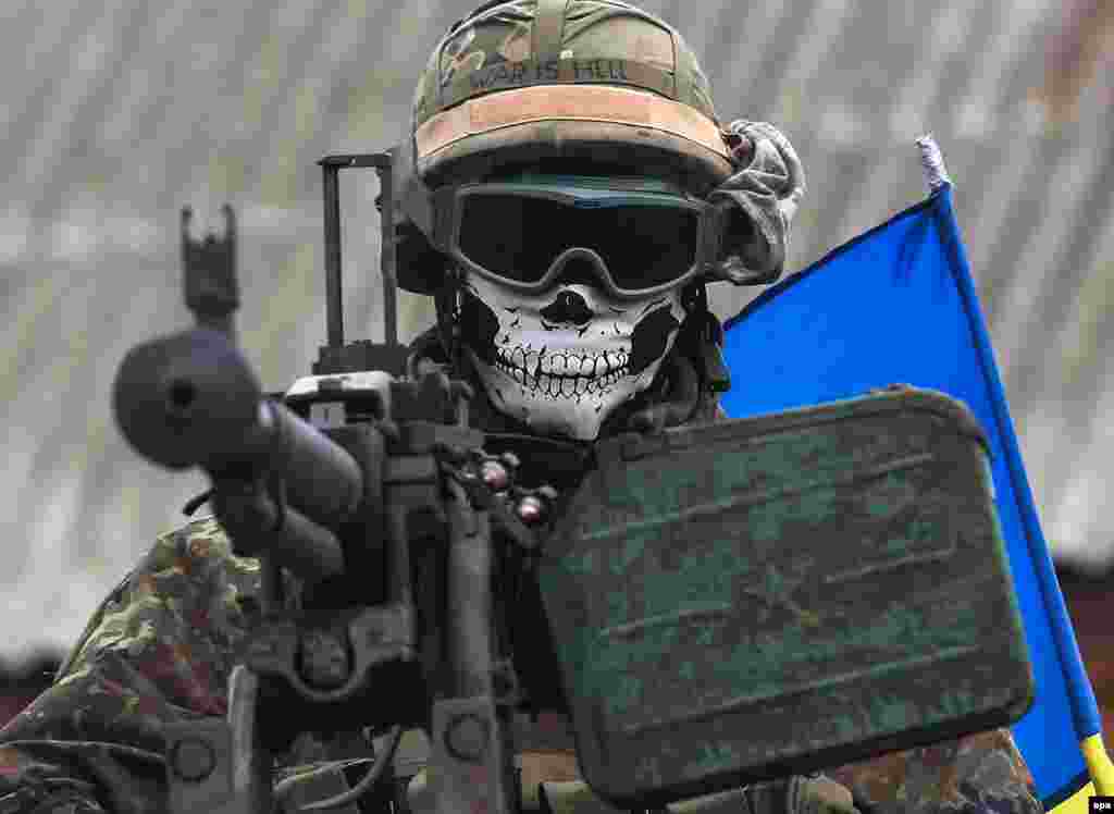 A masked Ukrainian serviceman, with the words 'War Is Hell' written on his helmet, is seen on an armored military vehicle near the eastern Ukrainian city of Debaltseve. (epa/Konstantin Grishin)