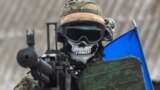 Militar ucrainean cu cuvintele 'War is Hell' scrise pe cască, în regiunea Donețk. 