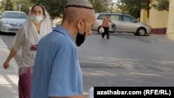 Чоловік із упаковкою захисних масок на вулиці Ашгабата, Туркменистан, 2021 рік
