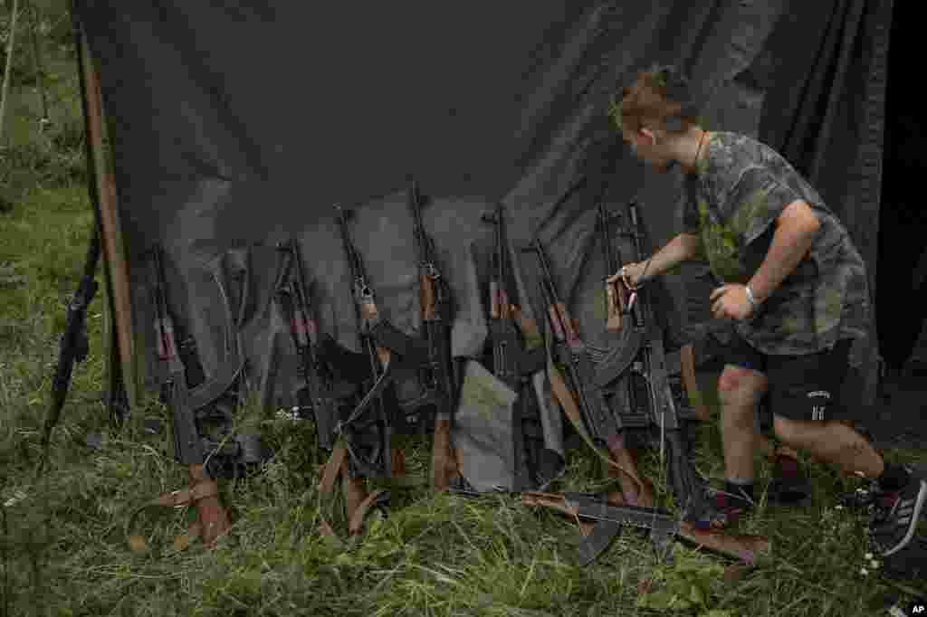 Жазғы лагерьдің қатысушысы қару таңдап жатқан сәт. 