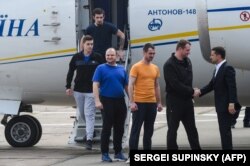 Ukrainian President Volodymyr Zelensky (right) welcomes former prisoners as they disembark from a plane on September 7.