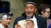 KAZAKHSTAN -- A supporter of Serikzhan Bilash, who has campaigned for the release of ethnic Kazakhs in China, holds a poster with his portrait standing in front of a court building in Almaty, Kazakhstan, Friday, Aug. 16, 2019.