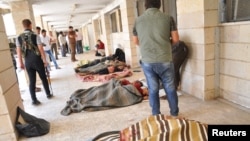 Люди осматривают тела убитых боевиками группировки ИГ в провинции Хасака в Ираке. Рас аль-Айн, 29 мая 2014 года.