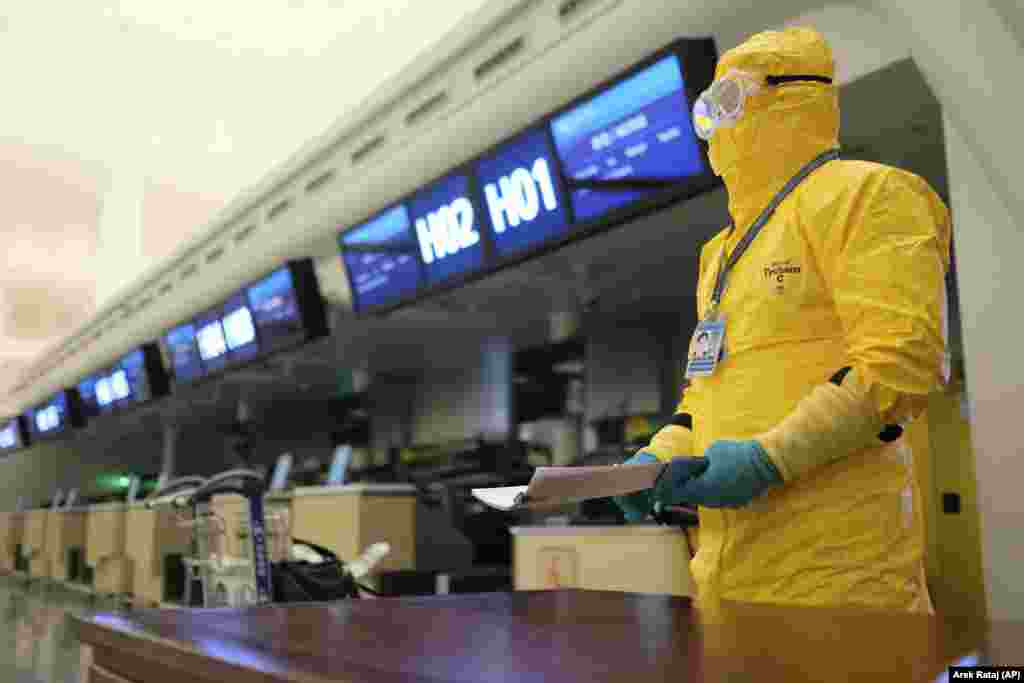 China -- In this Saturday, Feb. 1, 2020, photo, a worker in a protective suit holds paperwork before an evacuation flight for EU nationals at Wuhan Tianhe International Airport in Wuhan in central China's Hubei Province.