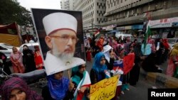 Supporters of Tahir-ul Qadri,hold his portrait during a protest in Karachi on June 19, 2014.