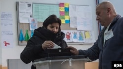 A woman casts her ballot in a voting rerun in one Macedonian election district.
