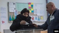 A voter casts a ballot on December 25 in an election rerun that was held in the Macedonian village of Tearce.