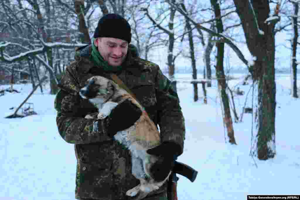 Офіцер з собакою. Крім собак, у військових в бліндажі живе кіт, а у їхніх товаришів по службі прямо на відкритому повітрі - качка.