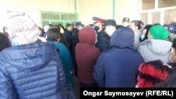 Гражданские и полиция в защитных масках у склада с продуктами.