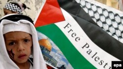 Фаластинлик бола "Озод Фаластин" деб ёзилган байроқ олдида.