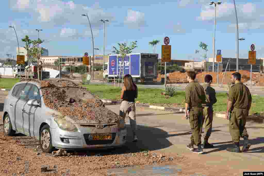 O mașină este acoperită de pământ, aruncat de impactul rachetei, în Tel Aviv. Fotografia a fost făcută în dimineața zilei de 2 octombrie, după ce Iranul a lansat un atac masiv cu rachete asupra Israelului în ziua precedentă.