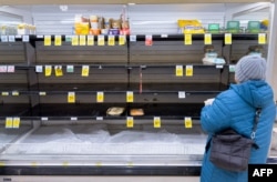 Виржиния штатындагы дүкөнгө кирген аял бош текчелердин жанында турат, 23-январь, 2026-жыл.