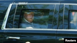 US President Donald Trump looks out of the window of his limousine as he departs the White House for his Virginia golf club on May 30. 
