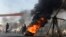 Activists of Imran Khan's Pakistan Tehrik-e Insaaf (PTI) party block a road with burning tires during an antigovernment protest in Lahore on December 15.