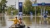 Місцеві жителі пливуть на човні вулицею під час евакуації із затопленої території після прориву дамби Нової Каховки в Херсоні, 7 червня 2023 року, ілюстративне фото
