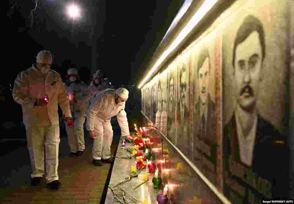 Працівники Чорнобильської АЕС запалюють свічки та кладуть квіти до пам&#39;ятника жертвам Чорнобильської катастрофи у місті Славутичі, 25 квітня 2021 року&nbsp;