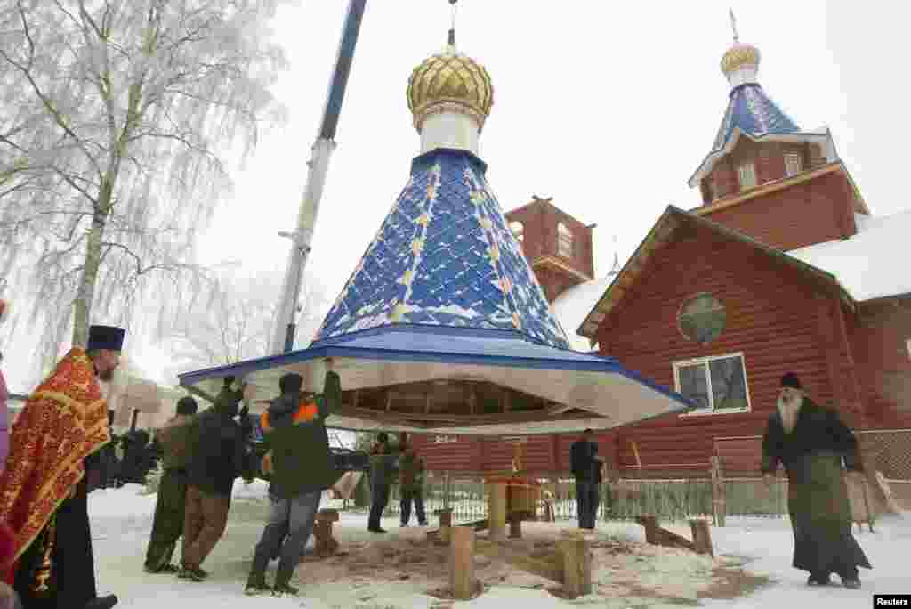 People lift a dome on an Orthodox church in the Belarusian town of Smilovichi, east of Minsk. (Reuters/Vasily Fedosenko)