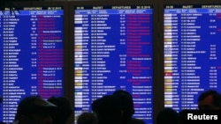 Passengers crowd in front of a flight board at the departure hall of Moscow's Domodedovo Airport on December 28.