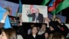 Supporters of Azerbaijani President Ilham Aliyev rally with national flags and his portraits after polls closed in a snap presidential election in Baku on February 7. 
