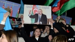 Supporters of Azerbaijani President Ilham Aliyev rally with national flags and his portraits after polls closed in a snap presidential election in Baku on February 7. 