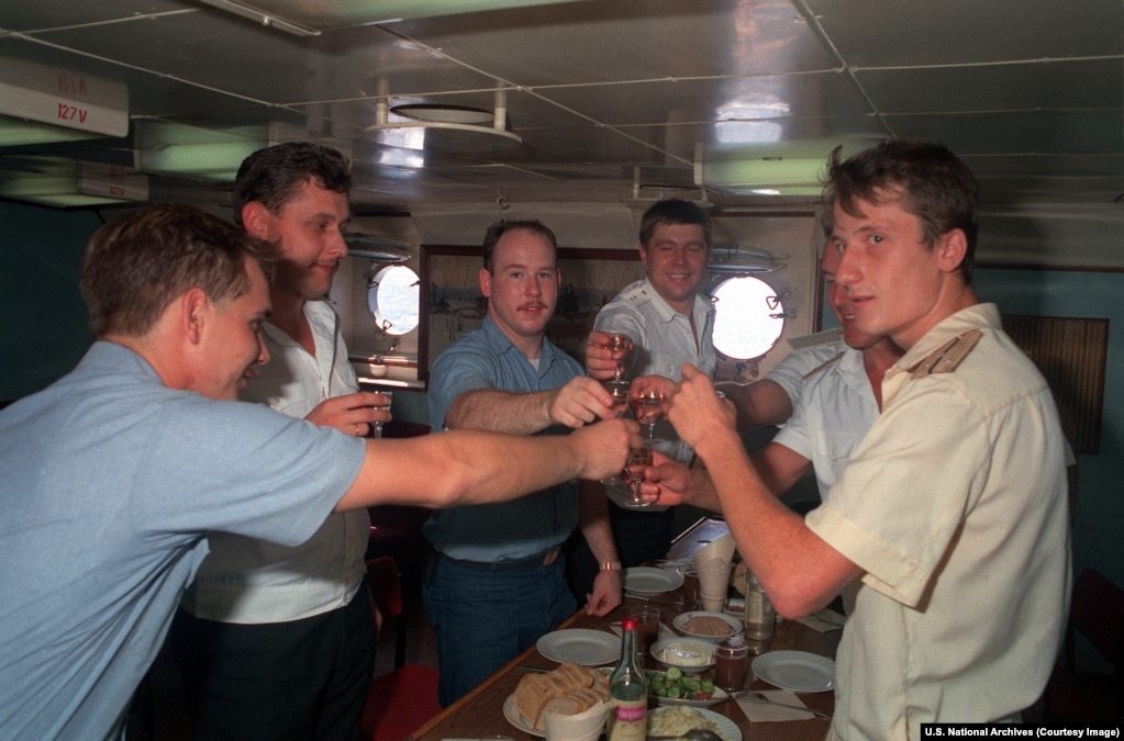 Russian and U.S. sailors prepare to down shots aboard a Russian guided missile destroyer.