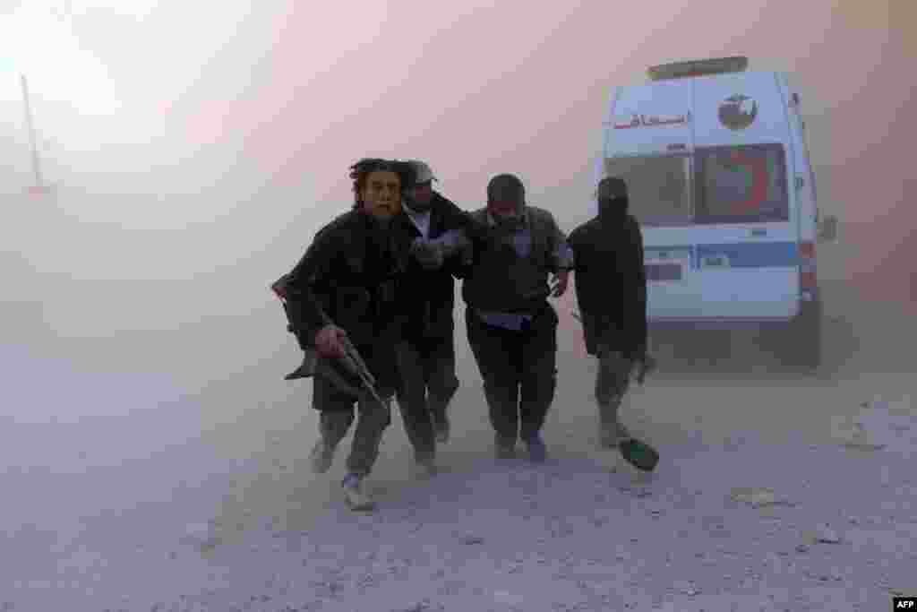  Fighters from the Al-Qaeda group in the Levant, Al-Nusra Front, help a wounded man following a reported barrel bomb attack by government forces in the Al-Muasalat area in the northern Syrian city of Aleppo. (AFP/AMC/Fadi al-Halabi)