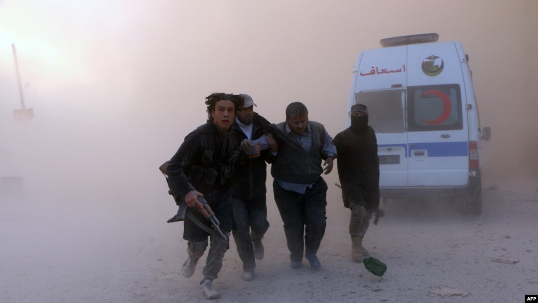 Rebel fighters help a wounded man following a reported barrel bomb attack by government forces in the northern Syrian city of Aleppo on November 6.