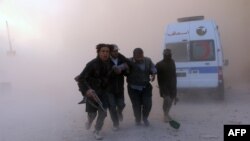 Rebel fighters help a wounded man following a reported barrel bomb attack by government forces in the northern Syrian city of Aleppo on November 6.