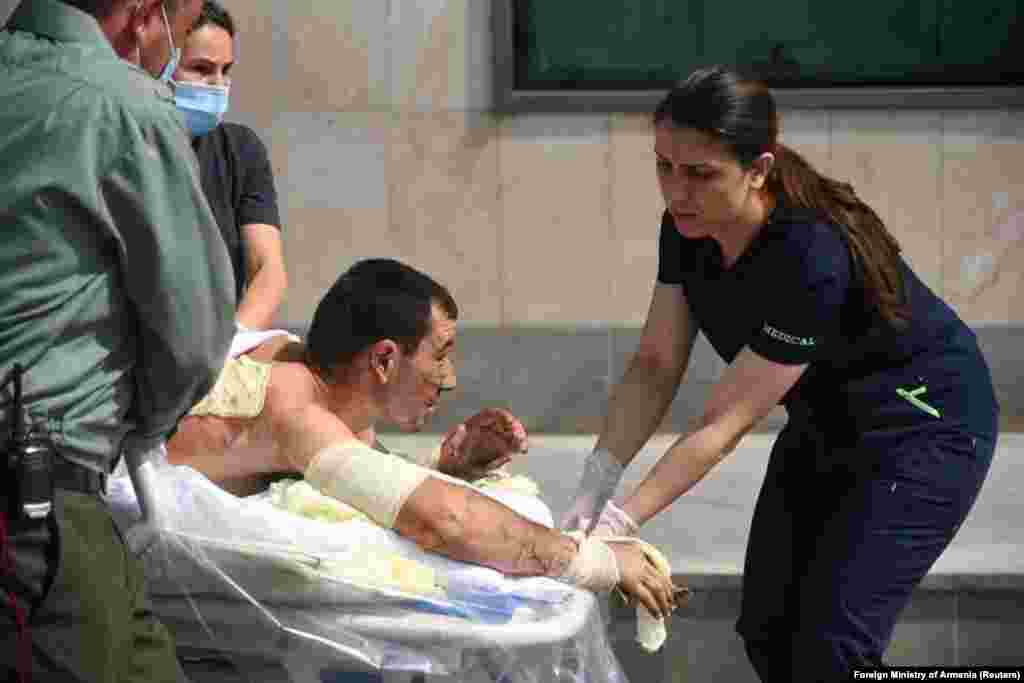 A handout photo released by the Armenian Foreign Ministry shows specialists delivering medical support to a civilian man believed to have been injured in the fighting.