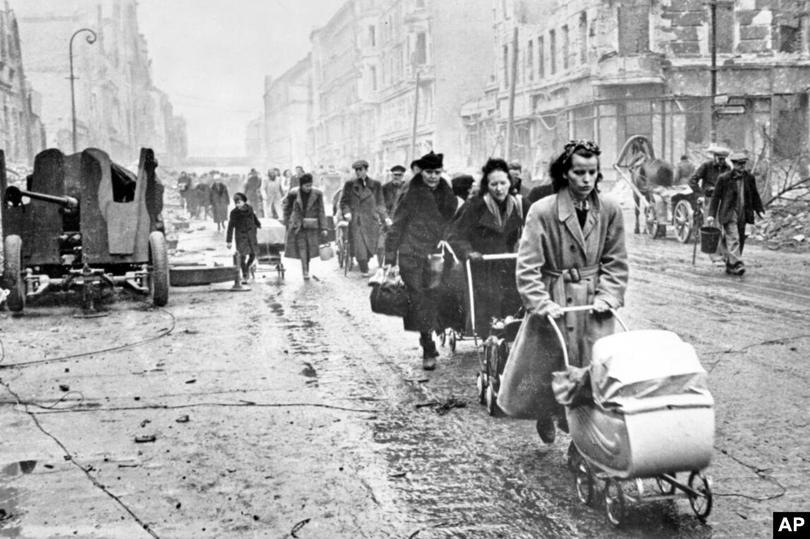 平民沿著被毀的柏林街道行走。  數千名德國婦女被蘇聯士兵強姦，迫使許多柏林女性在晚上的「狩獵時間」躲藏起來。只在清晨蘇聯軍隊熟睡時出現。