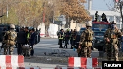 Afghan policemen inspect the site of a blast in Kabul on November 12.